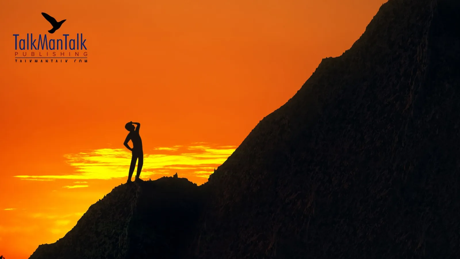 Silhouette of a climber on a steep mountainside at sunset