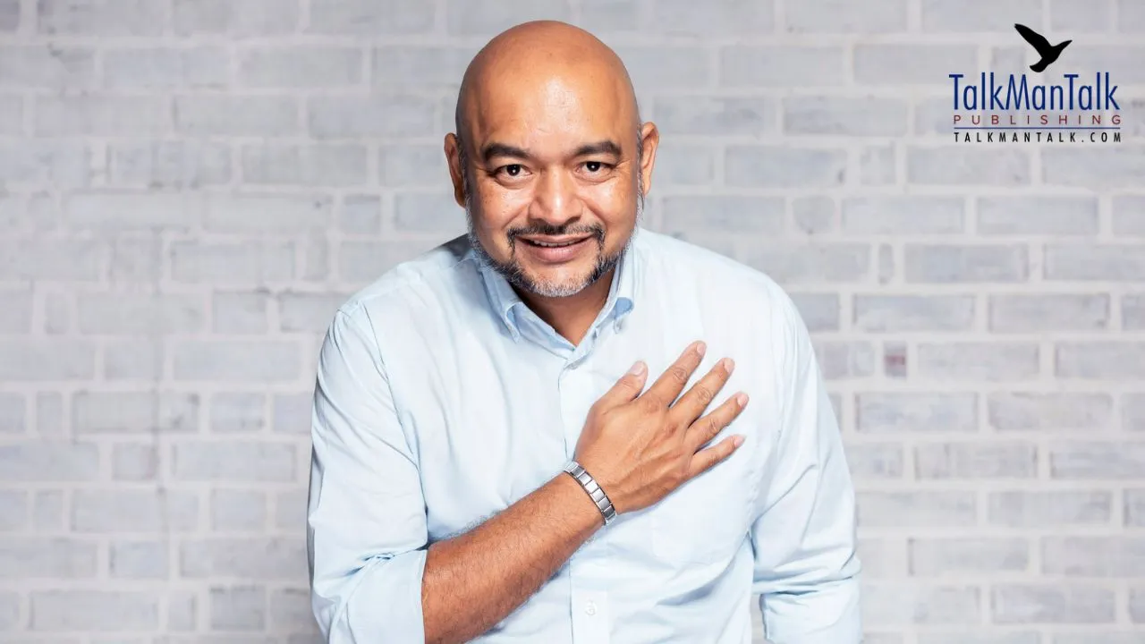 A smiling man with his hand over his heart